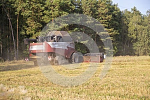 Old combine harvester harvests from the field