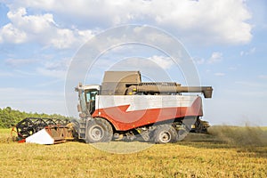Old combine harvester harvests from the field