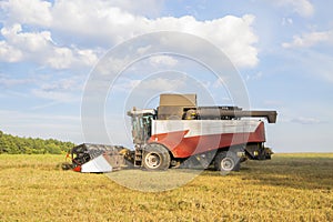Old combine harvester harvests from the field