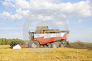 Old combine harvester harvests from the field