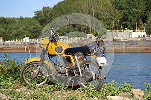 Old motorcycle near river. Vintage bike. photo