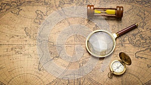Old compass , magnifying glass and sand clock  on vintage map