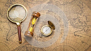 Old compass , magnifying glass and sand clock  on vintage map
