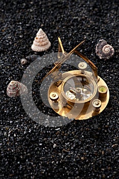 Old compass and sundial shells on a black background