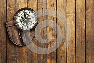 Old compass on wooden background with space for text