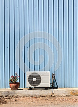 Old compressor air-conditioner and Flower Pot on zinc wall