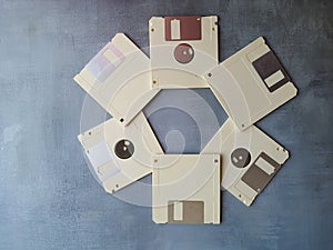 Old computer diskette, unlabeled, isolated, on a gray background.