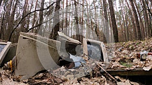 Old computer in a junkyard in the forest, slow motion