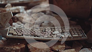 Old computer keyboard in an abandoned building is among the garbage