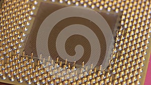 The Old Computer Processor CPU with Gold Plated Contacts Spins on Red Background
