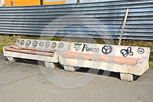 Old, concrete benches with pictures drawn by hooligans, in a city park