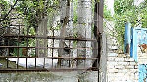 Old concrete fence of the industrial zone with a rusty metal grate.