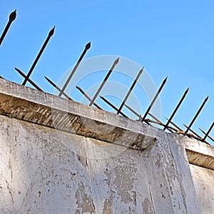 Old concrete fence with two-sided acute iron pins