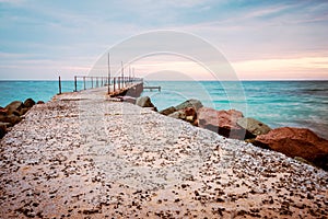 An old concrete sea bridge with rusty rails at the Black sea coast in Ravda, Bulgaria