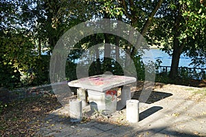 Old concrete table with stools by the river Spree. Berlin, Germany