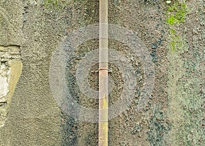 Old concrete wall with iron rusty pipe