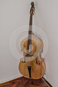 Old contrabass leaning against the wall