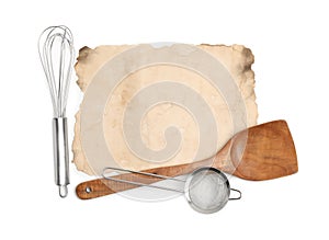 Old cookbook page and kitchen utensils on white background, top view. Space for text