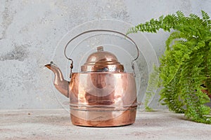 Old copper kettle on concrete background