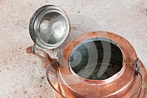 Old copper kettle on concrete background