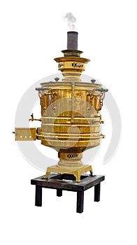 Old copper samovar with a chimney from which smoke comes stands on a small table isolated on a white background