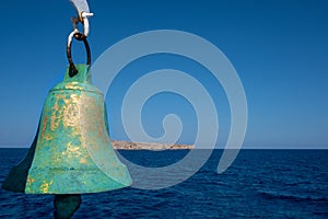 Old copper ship bell on the background of the sea