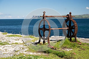 Old corroded iron winder with cogwheel, next to the sea, irish coast