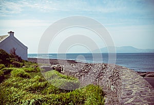 Old cottage with stone fence overlooking water