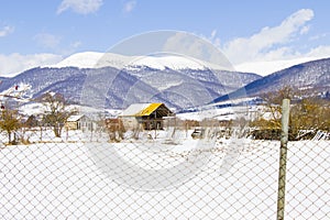 Old cottage in a village in a snowy landscape in Georgia