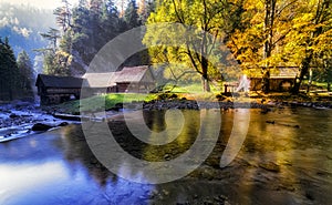 Old cottages under colorful trees and river