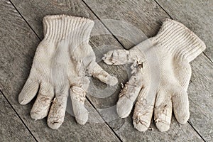 Old cotton work gloves on weathered wood.