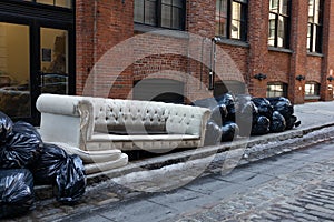 Old Couch and Trash Bags along a Street in Dumbo Brooklyn of New York City