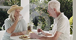 Old couple, glass and drinking or cheers happy in garden for retirement connection, talking or pineapple snack. Man