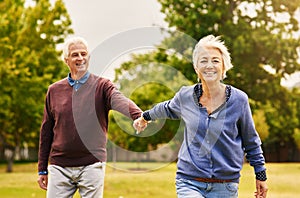 Old couple holding hands, outdoor in park and smile, happiness with freedom in nature, love and retirement. Happy, man
