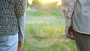 Old couple looking into future, standing apart in park indifference and break-up