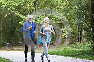 Old couple of pensioners running in park
