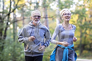 Old couple of pensioners running in park