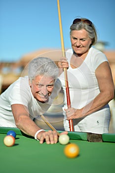 Old couple playing billiard