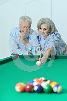 Old couple playing billiard
