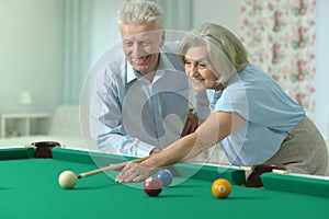 Old couple playing billiard