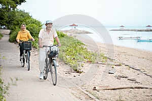 Old couple ride bicycle together