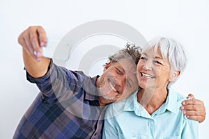 Old couple, selfie and hug, happy together and social media post for memory and love on white background. Trust, support