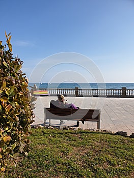 Old couple sitting on the bench with sea view, senior couple