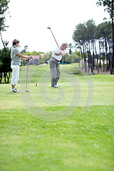 Old couple, sports or golfer playing golf for fitness, workout or exercise to swing on course or field. Senior woman