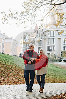 Old couple is walking in the green park. Fifty years together love story. Grandma and grandpa kissing. Grandmother and grandfather