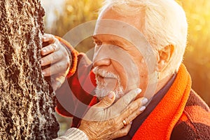 Old couple is walking in the green park. Fifty years together love story. Grandma and grandpa kissing. Grandmother and grandfather