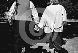 Old couple is walking in park. Grandmother and grandfather at golden wedding anniversary celebration. Fifty years love story.