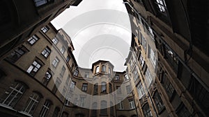 Old courtyard in the historic center of St. Petersburg. Action. Bottom view of a court yard in a form of well on cloudy