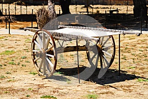 An old covered wagon wheel. Traditional wooden tumbrel,