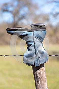 Old cowboy boot hanging on a fence in the Texas Hill Country
